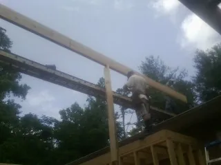 Carpenter setting a ridge beam over a new addition frame — Ice Dam Removal by Roofing Brothers in Vashon