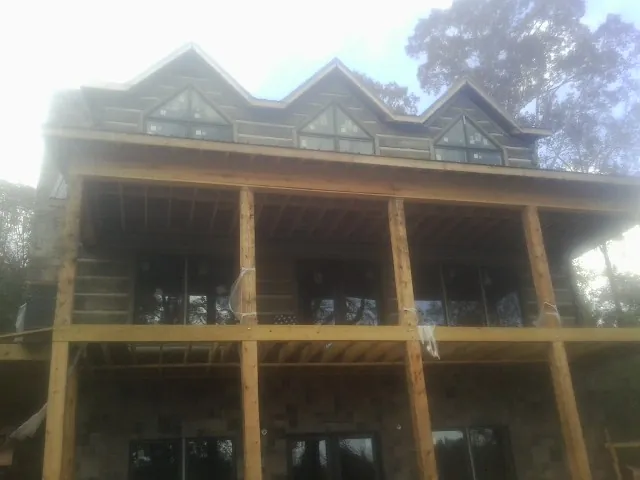 Dormers and porch framing on a large log home under construction — Roof Coating work by our crew in Vashon